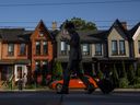 A person walks by a row of houses in Toronto.