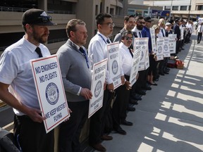 WestJet airplane mechanics stand in a the picket line at Calgary International Airport in Calgary, on June 29, 2024.