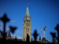 A person walks past the Peace Tower on Parliament Hill in Ottawa on Feb. 13, 2024.