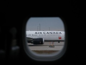 Air Canada plane viewed through window of adjacent aircraft.