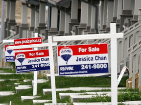 Row of for sale signs in front of houses