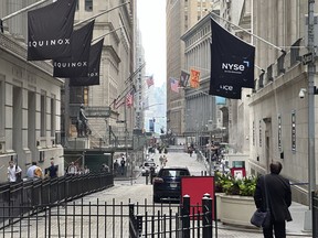 FILE - A man walking on Wall Street approaches the New York Stock Exchange, right, on June 26, 2024, in New York. Shares advanced in Europe on July 1, 2024, with the benchmark in Paris up 2.8% briefly after the far-right National Rally gained a strong lead in first-round legislative elections.