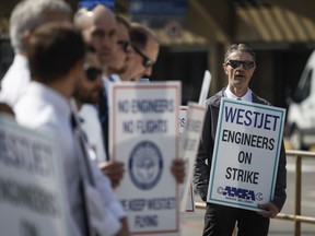 WestJet airplane mechanics stand in a the picket line