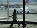 A traveller passes Air Canada planes at Pearson International Airport in Toronto, on March 18, 2012.