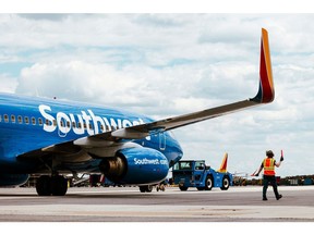 Agen jalan berjalan di bawah sayap pesawat Southwest Airlines Boeing 737-700 saat didorong mundur dari gerbang keberangkatan di Bandara Baltimore-Washington (BWI) di Baltimore, Maryland, AS, pada Jumat, 12 April 2024. Southwest Airlines Co. dijadwalkan merilis angka pendapatan pada 25 April.