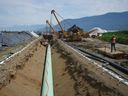Pekerja meletakkan pipa selama pembangunan ekspansi pipa Trans Mountain di tanah pertanian, di Abbotsford, BC, pada hari Rabu, 3 Mei 2023.