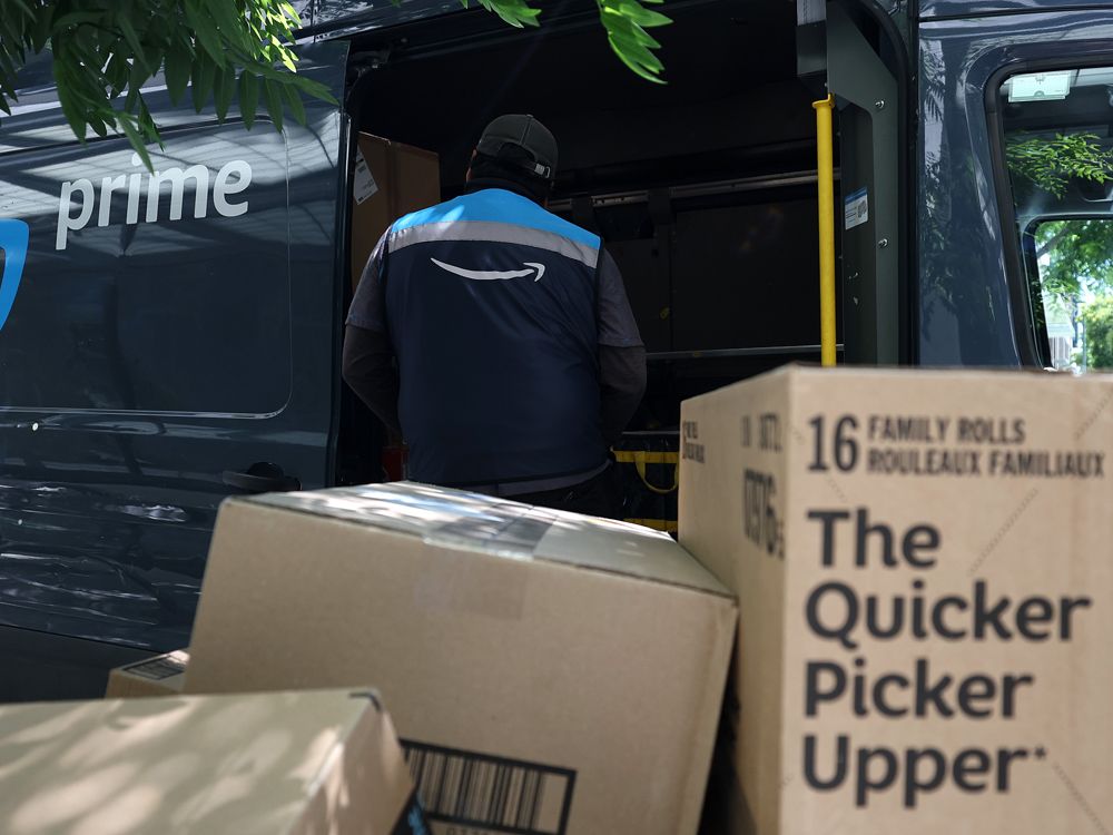 An Amazon.com Inc. delivery driver loads a cart with packages in San Francisco, California. 
