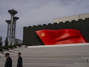 FILE - Visitors pass a flag of the Chinese Communist Party at the museum of the Communist Party of China in Beijing, Oct. 19, 2023.