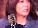 Republican presidential nominee former U.S. President Donald Trump watches as a video featuring Democratic presidential nominee Vice President Kamala Harris plays during a campaign event, Oct. 18, 2024 in Detroit.