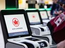 Travellers are seen around the Air Canada check-in kioks at the Calgary International Airport on Sept. 12, 2024.