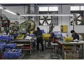 Workers sort casters at a factory operated by the Guangdong Shiyi Furniture Co. in Foshan, China, on Tuesday, Feb. 28, 2017. Startup E-Deodar, a wholly-owned subsidiary of Ningbo Techmation Co., is building $15,000 industrial bots that are about a third cheaper than foreign brands and are being used to automate assembly lines across the Pearl River Delta manufacturing hub. China is embracing robotics with the same full-on intensity that's made it a force in high-speed rail and renewable energy. Photographer: Qilai Shen/Bloomberg