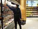 A shopper reaches for groceries in a new