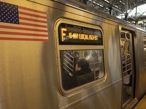 FILE - Para penumpang duduk di kereta F di Stasiun Coney Island-Stillwell Avenue, Kamis, 26 Desember 2024, di New York.