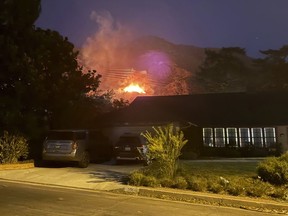 Dalam foto yang disediakan oleh Pasadena, California, penduduk Matt Logelin, api membakar di bawah menara transmisi yang dimiliki oleh Southern California Edison di Eaton Canyon pada sore hari Selasa, 7 Januari 2025.