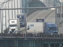 Trucks enter into the United States from Ontario, Canada across the Ambassador Bridge, on Feb. 3, 2025, in Detroit.