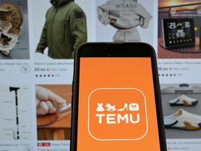 This photo illustration shows the logo of Chinese e-commerce company Temu displayed on a mobile phone in front of a screen bearing a website page of the company, in Brussels on Nov. 4, 2024.