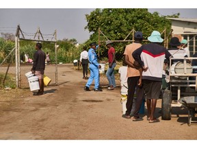 Residents queue to collect water from a reservoir in Bulawayo. Photographer: Zinyang Auntony/Bloomberg