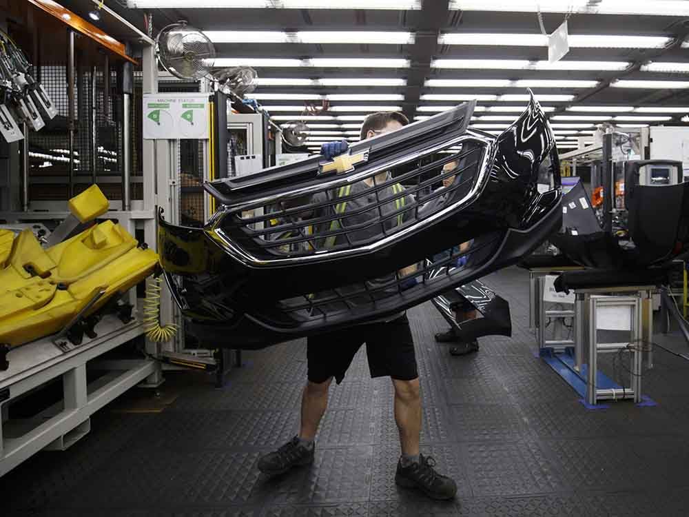 An employee carries a General Motors Chevrolet bumper at the Magna International Inc. Polycon Industries auto parts manufacturing facility in Guelph, Ont. Canada and Mexico were responsible for producing about 22 per cent of vehicles sold in the U.S. last year.