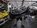 An employee carries a General Motors Chevrolet bumper at the Magna International Inc. Polycon Industries auto parts manufacturing facility in Guelph, Ont. Canada and Mexico were responsible for producing about 22 per cent of vehicles sold in the U.S. last year.