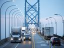 Commercial trucks and passenger vehicles drive across the Ambassador Bridge on the Canada-United States border in Windsor, Ont.