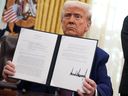 U.S. President Donald Trump shows the executive order on reciprocal tariffs in the Oval Office at the White House on Thursday.