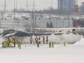 Investigators examine the wreckage of a Delta Air Lines plane a day after it crashed on landing at Toronto Pearson International Airport in Toronto, Ontario, February 18, 2025.