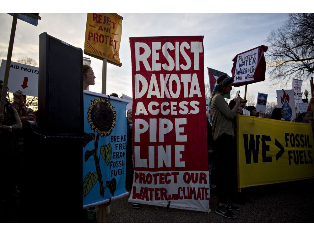 Demonstrators hold signs as they protest the building of the Dakota Access pipeline (DAPL) near the White House in Washington, DC, US, on Wednesday, Feb. 8, 2017. The US Army said it will grant Energy Transfer Partners LP the easement it needs to finish the line that will ship almost half a million barrels of crude a day from North Dakotas shale fields to refineries across the Midwest and on to the Gulf Coast.