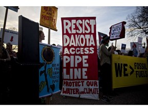 Demonstrators hold signs as they protest the building of the Dakota Access pipeline (DAPL) near the White House in Washington, DC, US, on Wednesday, Feb. 8, 2017. The US Army said it will grant Energy Transfer Partners LP the easement it needs to finish the line that will ship almost half a million barrels of crude a day from North Dakotas shale fields to refineries across the Midwest and on to the Gulf Coast.