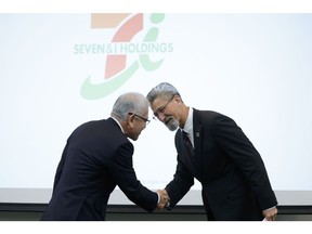 Ryuichi Isaka, left, shakes hands with Stephen Dacus during a news conference in Tokyo, on March 6.