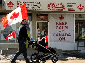 Canadian flags and a Keep Calm And Canada On sign decorate the outside of an Edmonton store. Canadian flags and a Keep Calm And Canada On sign decorate the outside of an Edmonton store.