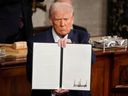 U.S. President Donald Trump holds up a signed executive order as he addresses a joint session of Congress at the Capitol in Washington, Tuesday.