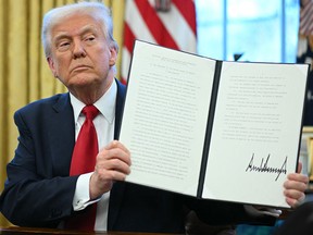 Donald Trump displays an executive order in the Oval Office of the White House on March 26.