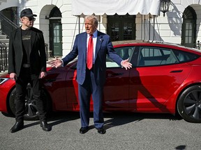 Presiden Donald Trump dan CEO Tesla Elon Musk berbicara dengan wartawan di dekat kendaraan Red Model S Tesla di halaman selatan Gedung Putih pada bulan Maret.