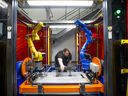 A worker adjusts a robotic MIG welding cell at the Martinrea International Inc. technical centre in Auburn Hills, Michigan, U.S.