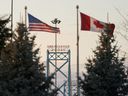 Canadian and American flags fly on the Canadian side of the Ambassador Bridge in Windsor, Ont.