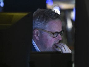 A trader works on the floor of the New York Stock Exchange at the opening bell in the Financial District of New York City.