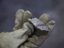 A worker holds a chunk of Bessemer matte at the Vale Copper Cliff Smelter Complex in Sudbury, Ont.