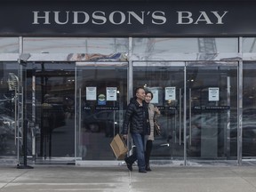 People leave Sherway Gardens’ Hudson’s Bay Co. store with bags of retail items in Toronto on March 24.