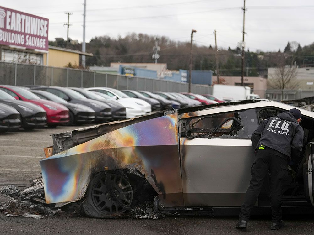 Seorang anggota Departemen Pemadam Kebakaran Seattle memeriksa Tesla CyberTruck yang terbakar di tanah Tesla di Seattle.