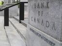 Pedestrians walk past the Bank of Canada in Ottawa on July 12, 2023.