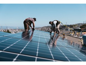 Pekerja memasang panel surya di atap rumah di San Francisco, California. Fotografer: Michaela Vatcheva/Bloomberg