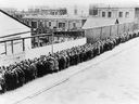 A long line of unemployed and homeless men wait outside to get free dinner at the municipal lodging house during the Great Depression, in New York, circa 1930.
