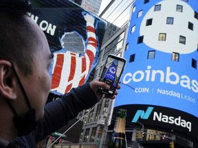 FILE - The Coinbase logo covers the Nasdaq MarketSite in New York's Times Square, April 14, 2021.