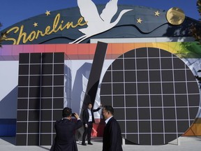 People pose for photos in front of an I/O logo at a Google I/O event in Mountain View, Calif., Tuesday, May 20, 2025.