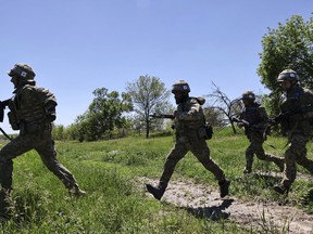 In this photo provided by Ukraine's 65th Mechanized Brigade press service, Ukrainian servicemen practice at the military training ground in the Zaporizhzhia region, Ukraine, Thursday, May 22, 2025,