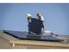 Contractors install SunRun Inc. solar panels on the roof of a new home at the Westline Homes Willowood Cottages community in Sacramento, California, U.S., on Wednesday, Aug. 15, 2018. California is the first state in the U.S. to require solar panels on almost all new homes as part of a mandate to take effect in 2020.