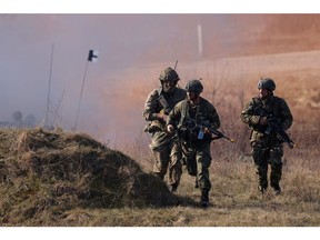 Soldiers of the United Kingdom's 2nd Battalion Royal Anglian infantry unit storm an enemy position in a simulated attack during the NATO