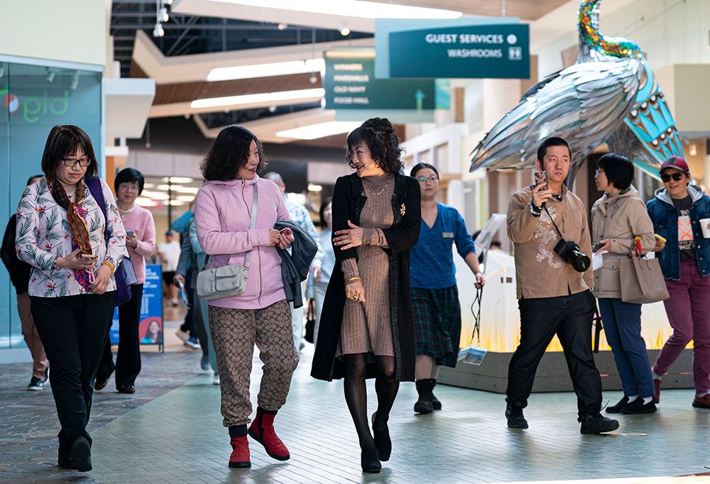 Weihong Liu, centre, walks through the Tsawassen Mills Shopping Mall in Delta in May. Weihong Liu, centre, walks through the Tsawassen Mills Shopping Mall in Delta in May.