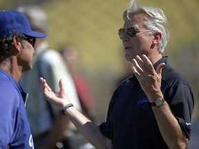 FILE - Los Angeles Dodgers co-owner Mark Walter, right, talks with manager Don Mattingly prior to their baseball game against the San Diego Padres, Sept. 3, 2012, in Los Angeles.