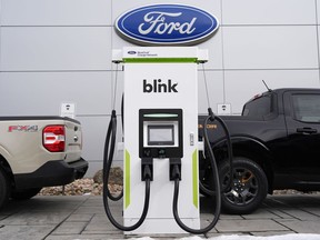 FILE - Electric vehicle chargers sit outside a Ford dealership, Jan. 21, 2024, in Broomfield, Colo.